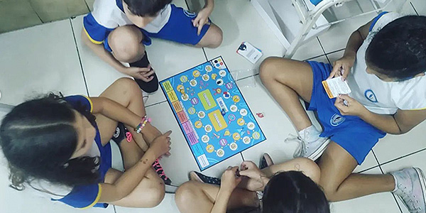 jogo de tabuleiro no chão e crianças brincando 